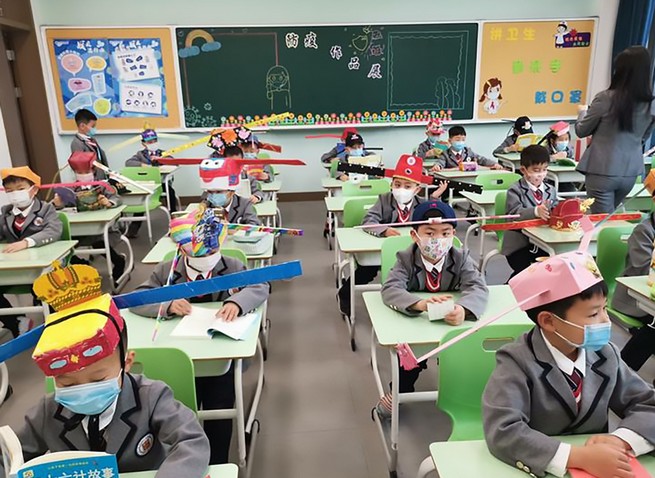 Chiny eksperymentują z czapkami dla dzieci, żeby zachowywały dystans