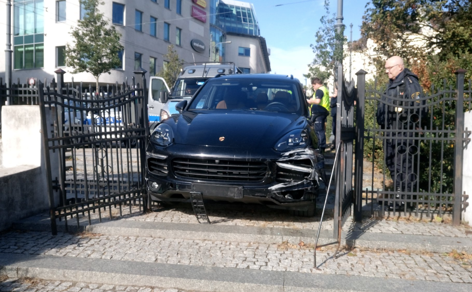 Porsche staranowało trzy radiowozy, próbowało przejechać policjanta i utknęło w bramie