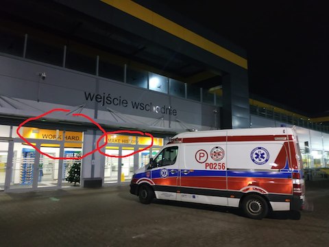 Karetka pod siedzibą Amazona pod Poznaniem. W tle napis "Work hard, make history"